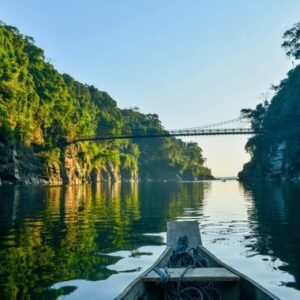 Boat on a clear river between forested hills in Meghalaya